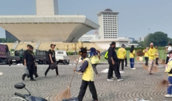 Polisi Bantu Petugas Kebersihan Bersihkan Monas Usai Aksi Buruh